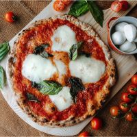 Margherita Pizza with rustic tomato sauce, Fior di latte, basil, and Parmesan
